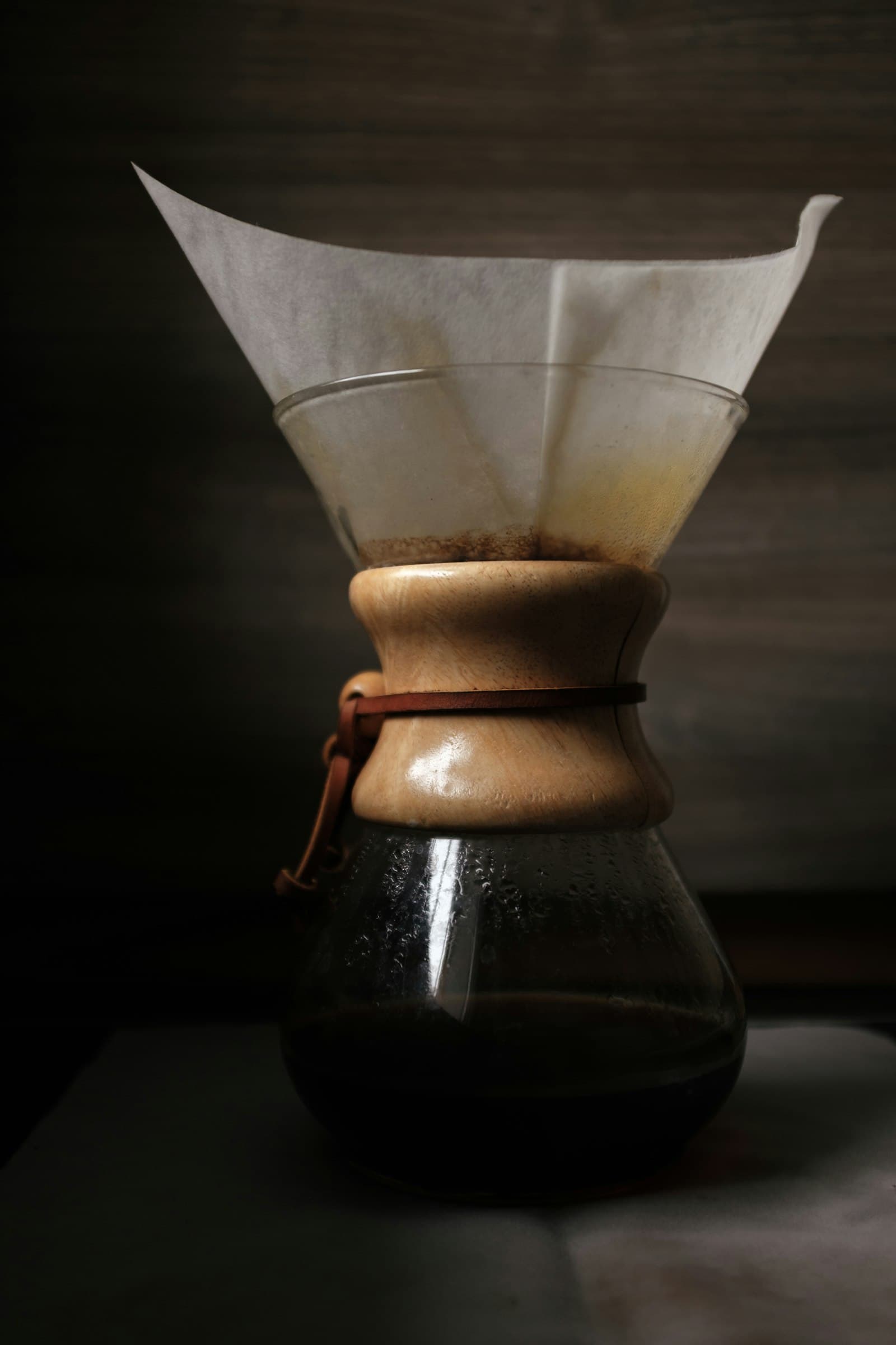 木製カラーと紙フィルターをセットしたケメックスで抽出されるコーヒー